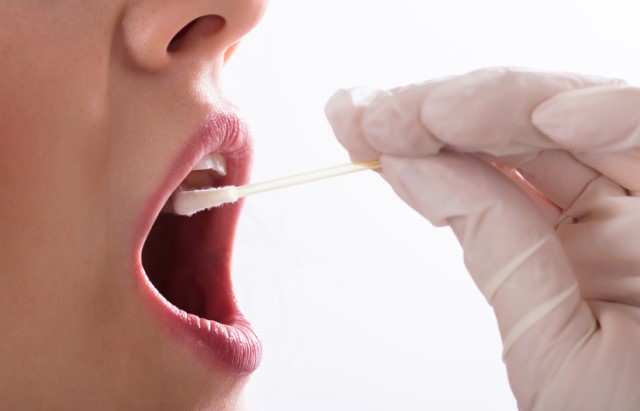 一只戴著手套的手在一個人的臉頰內側擦拭.jpg 一只戴著手套的手在一個人的臉頰內側擦拭.jpg